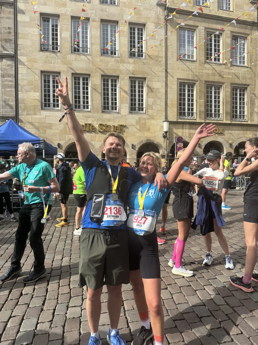 Ertmann und seine Freundin im Ziel des Marathons, mit erhobenen Armen und Medaillen